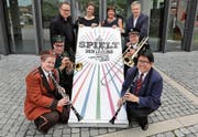 Vertreter des OKs präsentieren das Festlogo (von links): Nadine Bircher, Raphael Suter, Andreas Gnädinger, Corine Stocker, Regula Hürlimann, Markus Maurer (Zuger Blasmusikverband), Matthias Schleiss und Theres Moos. (Bild: Daniel Frischherz (Hünenberg, 30. Mai 2017))