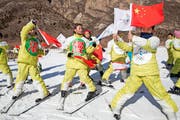 Werbung für Pekings Olympiabewerbung: Dort, wo 2022 die Bobwettbewerbe stattfinden sollen, versuchen chinesische Schüler schon einmal olympisches Flair zu vermitteln und das Logo der Bewerbung in Szene zu setzen. (Bild: AP/Ng Han Guan)