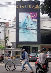 Strassenszene in Jakarta. Im Hintergrund das islamische Bekleidungsgeschäft Shafira. (Bild: Graham Crouch (Jakarta, 22. Januar 2018))