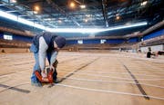 Christopfer Bryan verlegt mit seinen Arbeitskollegen Heizungsröhren in der Bossard-Arena. (Bild Stefan Kaiser/Neue ZZ)