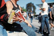Jugendliche prosten sich auf einem öffentlichen Platz mit einem Bier zu. (Bild: Boris Bürgisser)