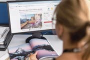 Eine junge Frau stöbert auf der Seite von Airbnb in den Angeboten für die Schweiz. (Bild: Gaetan Bally/Keystone (4. September 2014))
