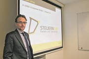 Finanzdirektor Urs Janett stellt das neue Logo vor, das von nun an für alle Schriftstücke rund um die Steuern bei Kanton und Gemeinden verwendet wird. (Bild: Markus Zwyssig (Altdorf, 29. März 2018))