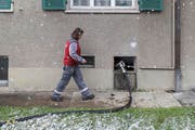 Ein Mitarbeiter beim Auffüllen eines Heizöltanks. (Bild: Gaetan Bally / Keystone)