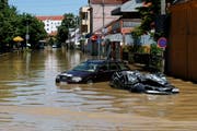 Ein komplett zerstörtes Auto liegt völlig überflutet in einer Strasse in Obrenovac, etwa 30 Kilometer südwestlich von der serbischen Hauptstadt Belgrad. (Bild: AP Photo/Darko Vojinovic)