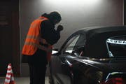 Ein Polizist leuchtet ins Innere eines Autos. (Bild: Zuger Polizei)