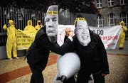 Kampagnen sind ihr Geschäft: Ican-Aktivisten protestieren vor Nordkoreas Botschaft in Berlin – mit Masken von Machthaber Kim Jong Un und US-Präsident Donald Trump. (Bild: Britta Pedersen/DPA (13. September 2017))