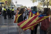 Eine Gruppe junger Menschen trägt die Flagge von Katalanien in Barcelona. (Bild: EPA/JIM HOLLANDER)