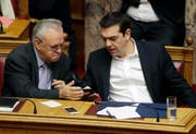 FILE - In this Friday, Feb. 24, 2017 file photo Greek Prime Minister Alexis Tsipras, right, speaks with the Deputy Prime Minister Giannis Dragasakis, during a Parliament session about bailout negotiations in Athens. Prime Minister Alexis Tsipras on Wednesday, Feb. 28, 2018 has appointed deputy premier Yannis Dragasakis as the country's economy and development minister in a limited cabinet reshuffle triggered by a rent allowance scandal. (AP Photo/Thanassis Stavrakis, File) (Bild: Thanassis Stavrakis / AP / Keystone (Athen, 24. Februar 2017))