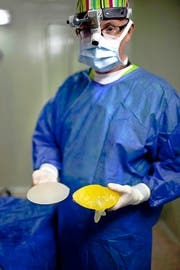 Ein Arzt zeigt fehlerhafte Brustimplantate. In Frankreich zum Beispiel gab es deswegen schon Sammelklagen. (Bild: Keystone)