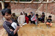 epa06397847 Rohingya children wait for their parents to receive aid at the Balukhali food distribution centre near Cox's Bazar in Bangladesh, 19 December 2017. More than 646,000 Rohingya refugees have crossed the border from Myanmar into Bangladesh following the Myanmar army's August crackdown on Rohingya rebels in the state of Rakhine state. Traveling with assistance from Save the Children. EPA/Tracey Nearmy AUSTRALIA AND NEW ZEALAND OUT (Bild: Tracey Nearmy/EPA/AAP)