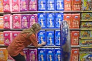 Eine Migros-Mitarbeiterin füllt ein Regal mit Windeln auf. (Bild: Keystone)