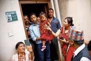Die dreijährige Trishna Shakya wird von ihrem Vater zum Kloster gebracht. (Bild: Bikram Rai/Keystone (Kathmandu, 28. September 2017))
