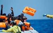Bilder wie dieses sind in den letzten Monaten traurig vertraut geworden: Flüchtlinge im Mittelmeer vor der Küste Libyens. Hier rüsten Rettungskräfte eine Gruppe mit Schwimmwesten aus. (Bild: AP/Gregorio Borgia)