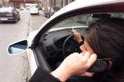 Rauchen und telefonieren im Auto führt zu Unaufmerksamkeit im Strassenverkehr (gestellte Szene). (Bild: Archiv Neue ZZ)