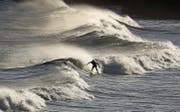 Im Tynemouth geniesst ein Surfer einen Ritt auf den Wellen der Nordsee. (Bild: Owen Humphreys/AP)