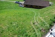Die Spuren der Irrfahrt sind in der Wiese deutlich sichtbar. Unten die Baracke und die zwei beschädigten Autos. (Bild: Kantonspolizei Obwalden)