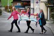 Kerstin Harris, Cornelia Rogenmoser und Tanja Kneringer (von links) von der Frauengemeinschaft Unterägeri mit einer Bank, die speziell für das Jubiläum entworfen wurde. (Bild: Stefan Kaiser (Unterägeri, 2. November 2017))