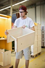 Der Zivildienstleistende Lars Troxler zeigt einen Ulmer Hocker, der in der Stiftung Brändi in Kriens produziert wird. (Bild Manuela Jans-Koch)