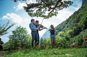 Das Geigenkonzert auf der Rütliwiese mit Sebastian Bohren (vorne) und Lech Antonio Uszynski. Rechts die Mädchen, die spontan die Noten festhalten. (Bild: Roger Grütter (30. Juli 2017))
