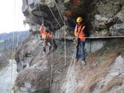 Bauarbeiter bei den Sicherungsarbeiten im Fels. (Bild: PD)