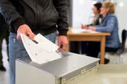Ein Mann wirft seine Zettel in einem Wahlbüro in eine Urne. (Bild: Keystone / Gian Ehrenzeller)