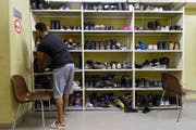 Ein Asylbewerber räumt in der Zivilschutzanlage in Dagmersellen Schuhe weg. Die Notunterkunft wurde im Januar dieses Jahres eröffnet und bietet, befristet bis Ende Jahr, Platz für bis zu 50 Bewohner. (Bild: Keystone/Anthony Anex)
