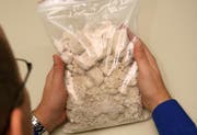 Ein Polizeibeamte zeigt ein Kilo Kokain. (Bild Chris Iseli/Neue LZ)