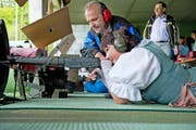 Conny Wicki schiesst in ihrer Tracht und wird von Schützenmeister Josef Felder instruiert. (Bild Dominik Wunderli)