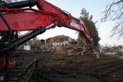 Wegen Einsturzgefahr rissen am Montag Bagger das abgebrannte Bauernhaus in Hünenberg ab. (Bild Stefan Kaiser/Neue ZZ)