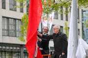 Gemeindepräsident Georges Helfenstein und Gemeinderat Markus Baumann gehen auf Tuchfühlung mit einer der neuen Fahnen. (Bild: Stefan Kaiser / Neue ZZ)
