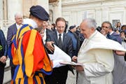 Gardist David Geisser (in Uniform) und Gardist Erwin Niederberger (Mitte), die beiden Autoren, übergeben auf dem Petersplatz Papst Franziskus ein Exemplar ihres Kochbuchs. (Bild «L’Osservatore Romano»)