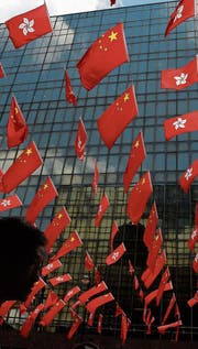 Die Fahnen von China und Hongkong wehen vor einem (Bild: Kin Cheung/AP (28. Juni 2017))