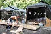Ein Handwerker schneidet am Mittwoch in Aarau Bodenplatten zurecht für die Militärzelte, die Asylbewerbern als temporäre Unterkunft dienen werden. (Bild: Keystone/Ennio Leanza)