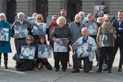Betroffene von fürsorgerischen Massnahmen posieren anlässlich der Einreichung der Wiedergutmachungsinitiative mit alten Fotos vor dem Bundeshaus. (Bild: Lukas Lehmann/Keystone (Bern, 31. März 2014))