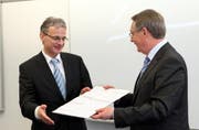 Franz Marty (rechts), Präsident der Verfassungskommission, überreicht Kantonsratspräsident Christoph Pfister die Vorlage der neuen Schwyzer Kantonsverfassung. (Bild Laura Vercellone/Neue SZ)