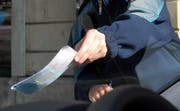 Ein Bussenzettel wird auf die Frontscheibe eines falsch geparkten Wagens gelegt. (gestellte Szene; Bild Adrian Stähli/Neue LZ)