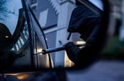 Ein Mann bricht in ein Auto ein (gestellte Szene). (Bild: Axel Heimken / DPA)