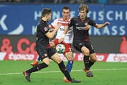 Hamburgs Filip Kostic wird von Leverkusens Panagiotis Retsos (links) und Tin Jedvaj in die «Zange» genommen. (Bild: Martin Rose/Getty)