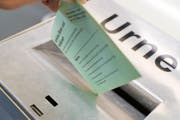 Ein Mann wirft ein Couvert in eine Urne. (Bild: Roger Grütter / Neue LZ)