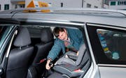 Manfred Zweifel von Taxi Keiser montiert einen Kindersitz im Auto. (Bild Stefan Kaiser/Neue ZZ)