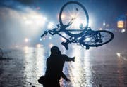 Mit einem Velo gegen Wasserwerfer: eine Szene der Hamburger Ausschreitungen. (Bild: Daniel Bockwoldt/Keystone (Hamburg, 9. Juli 2017))