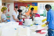 Junge Asylsuchende im Jugendwohnheim Waldheim bei der Arbeit am Kunstwerk «Unterwegs», eine aus Gipsfüssen bestehende Installation. (Bild: Dominik Zietlow)
