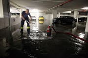 Ein Mitglied der Freiwilligen Feuerwehr Zug und eine Tauchpumpe sind in einer Tiefgarage im Einsatz. (Bild: PD/Stadt Zug)