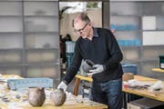 Kantonsarchäologe Jürg Manser mit dem Horn eines Auerochsen und weiteren Fundstücken, die in der Umgebung der Pfahlbauten bei Hitzkirch Seematt gefunden wurden. (Bild: Nadia Schärli (15. Februar 2018))