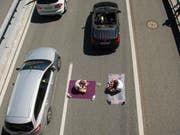 Zwei Ferienreisende haben es sich am Freitag beim Stau auf der A2 zwischen Erstfeld und Göschenen gemütlich gemacht. (Bild: /KEYSTONE/URS FLUEELER)