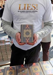 Ein Mitglied der «Lies!»-Bewegung präsentiert an einer Standaktion in Berlin einen Koran. (Bild: Getty/Adam Berry)