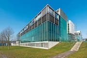 Die spiegelnde Glasfassade des Zuger Kantonsspital im Frühling. (Bild Christian H. Hildebrand)
