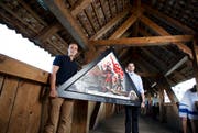 Die Initiativkomiteemitglieder Maurus Zeier (links) und Fabian Reinhard gestern mit einer der Bildkopien auf der Kapellbrücke. (Bild: Manuela Jans / Neue LZ)