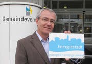 Der Megger Gemeinderat Josef Scherer präsentiert die neue Alutafel «Energiestadt». (Bild pd)